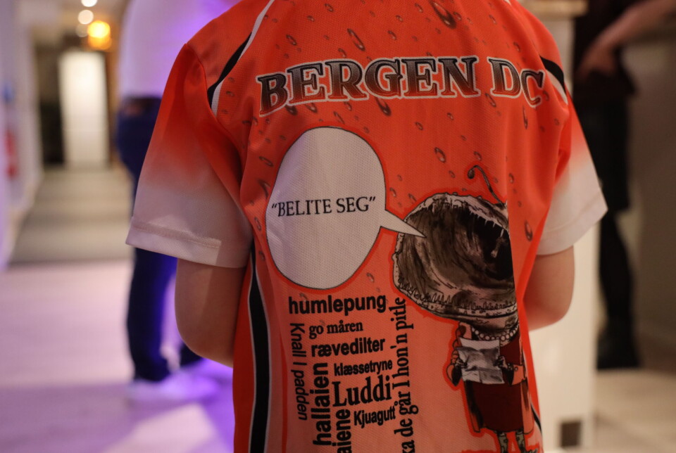 Som alle ekte dartspillere har Adrian Falck sin egen drakt. Ryggen er dekket av bergenske uttrykk.