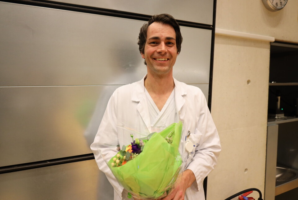 Overlege Knut Christian Lundekvam smiler fornøyd etter å ha fått utdelt blomster av Feministiske medisinere.